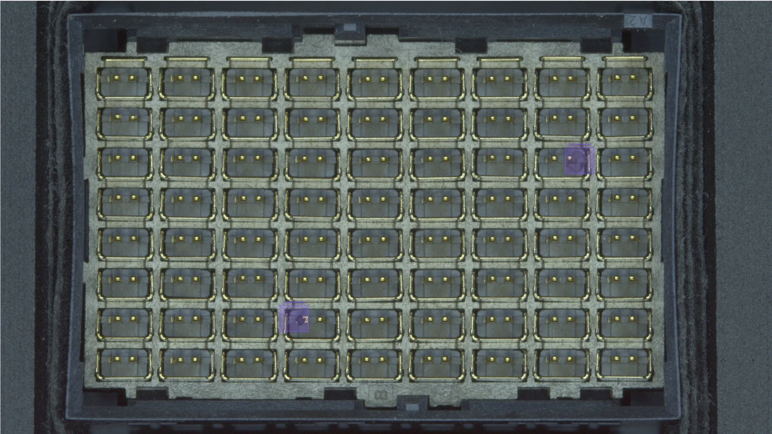 Full connector capture with two contamination regions highlighted, one a dark speck between pin cells and one a fibre lying across a pin cell